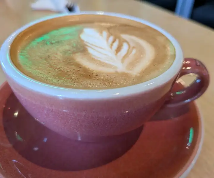Cappuccino z latte art w różowej filiżance