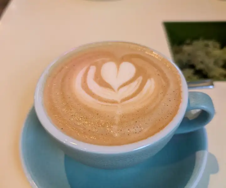 Latte z sercem w niebieskiej filiżance