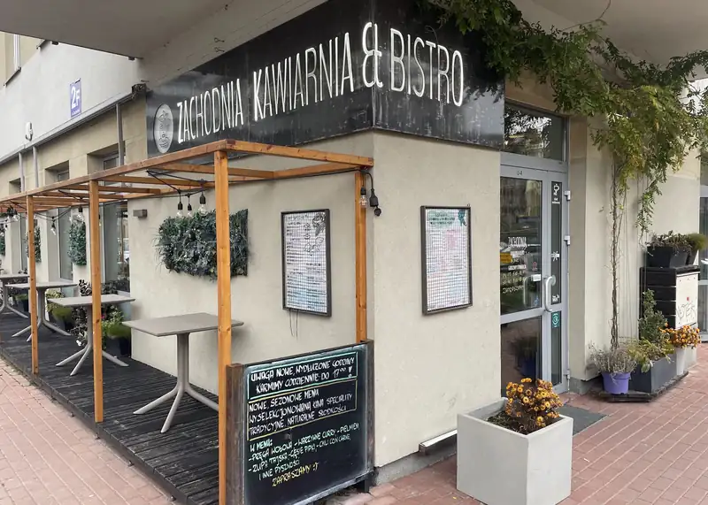 Wejście do Zachodniej Kawiarni & Bistro z szyldem i tablicą