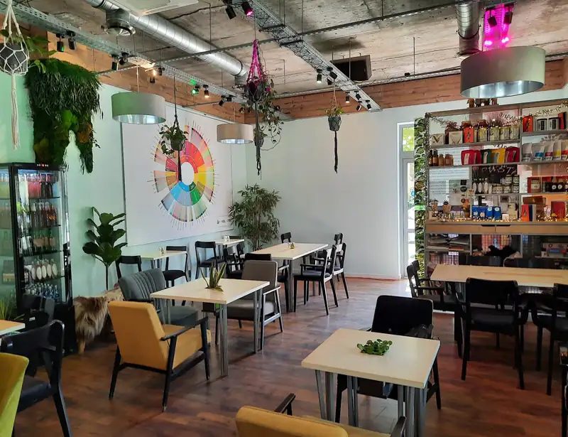 Sala z regałami, fotelami i kolorowym obrazem